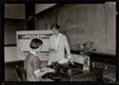 A pupil in typewriting class, High School, gets special help.