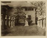 [Roman statue flanked by busts]