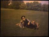 [Man lying on ground with two dogs]