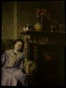 [Rose Silberstein, seated at fireplace in London home]