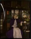 [Woman sitting in library]