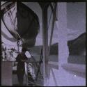 [Woman on deck of ship beneath lifeboat]