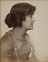 [Young woman (profile) with hair rolled up]