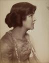 [Young woman (profile) with hair rolled up]