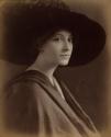 [Woman wearing large hat with feather]