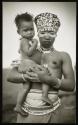 A young matron was encountered near Peddie, South Africa. We were informed that her low-browed headdress indicates her baby was her first child, and that white facial paint among the Xosas denotes a nursing mother