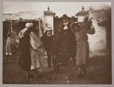 [Woman seated on donkey next to man holding basket of bread]