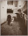 [People walking in cobbled Moroccan street]