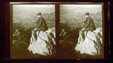 Will Connell, seated on rocky prominence lookong over area below