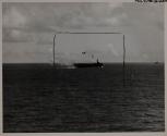 The approaching F6F, spotting the suicider at mast height, veers off to the left. Small arms weapons still pour out a stream of lead at the determined Japanese kamikaze.