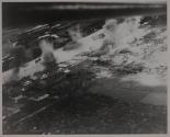 Ships and installations afire at Saigon River front, French Indo-China after aerial attack by carrier-based planes of US Pacific Fleet.