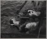 Flames still rage around the gaping hole torn by the torpedo when it struck the tanker approximately amidships on the port side.
