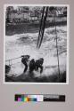 Seamen aboard the tanker USS Kaskaskia get a heavy dousing as they work on fuel lines leading to the battleship Massachusetts.