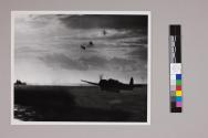 [A Japanese torpedo bomber aircraft named "Jill" flying over U.S. aircraft carrier]