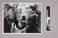 [Men loading a missle into a battleship gun]
