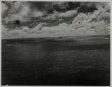 [Distant aerial view of ships and an airplane at sea]