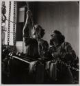 [Two women working on an engine]