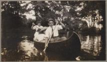 Man and three women rowing a canoe