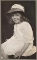 Seated girl wearing hat