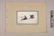Two boys sledding down a hill