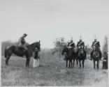[Soldiers on horses in a field]