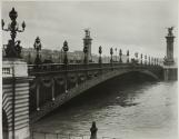 [People traveling over ornate bridge]