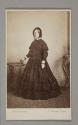[Woman in dress holding a book]