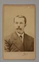 [Mustached man in suit]