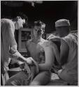 [Doctors and corposmen setting a cast for an Okinawa casualty on the hospital ship SOLACE]