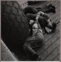 [Sleeping on the deck by an airplane tire]