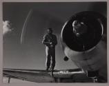 [Man on wing of airplane, probably Navy flight crew]
