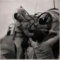 [Wounded gunner Kenneth Bratton is lifted from the turret of a torpedo-bomber on his return to the U.S.S. Saratoga. By applying a tourniquet to his leg, Bratton had remained conscious, and helped to ttacking Japanese planes.]