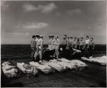 [Last Honors - The Navy pays tribute to its dead and gives them last honors in the tradition of men wh go to sea. Officers and men of a U.S. carrier stand at attention besides the bodies of shipmates killed the Second Battle of the Philippine Sea.]