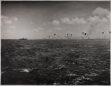 [A burning Japanese torpedo-bomber falls after being knocked down by artillery from American warships.]
