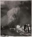[Architectural ruins beneath a cloud of smoke]