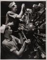 [Two men working on an aircraft engine]