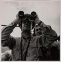 [Officer looking through binoculars]