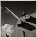 [Gun turret on ship, manned by bare-chested soldier]