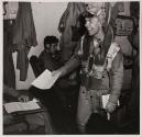 [Flight crew member smiling and holding document]