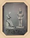 [Two figurines]