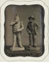 [Two figurines]