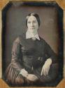 [Young woman, seated with head slightly turned]