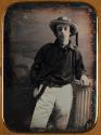 [Portrait of young sailor, James S. McKenzie, posing near a column, with a nautical scene on backdrop.]
