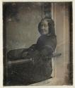 [Woman seated on windowsill]