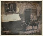 [Street scene with woman and donkey]