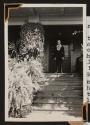 [Dr. Mueller standing on a porch wearing Hawaiian leis]