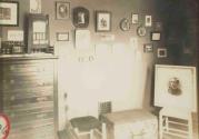 [Framed photographs on a wall and propped in a chair]