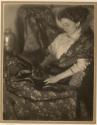 [A woman wrapped in a blanket, holding cat]