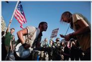 Washington, DC, Banjo Youngblood (left) and Jamie Troutman (right) sing the lyrics “the revolution has just begun” to a boisterous crowd in Freedom Square during the first day of "Occupy DC."