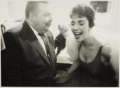 [Manager of El Morocco nightclub laughing with performer wearing a fur stole]